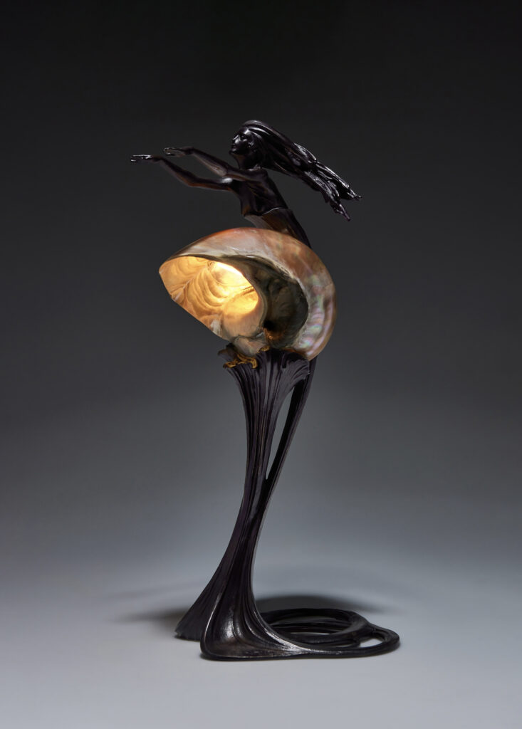 Art Nouveau lamp designed by Gustav Gurschner in 1898, made of patinated bronze with a Turbo marmoratus shell used as a lampshade, featuring an integrated female figure. Signed "899" and "Gurschner".
